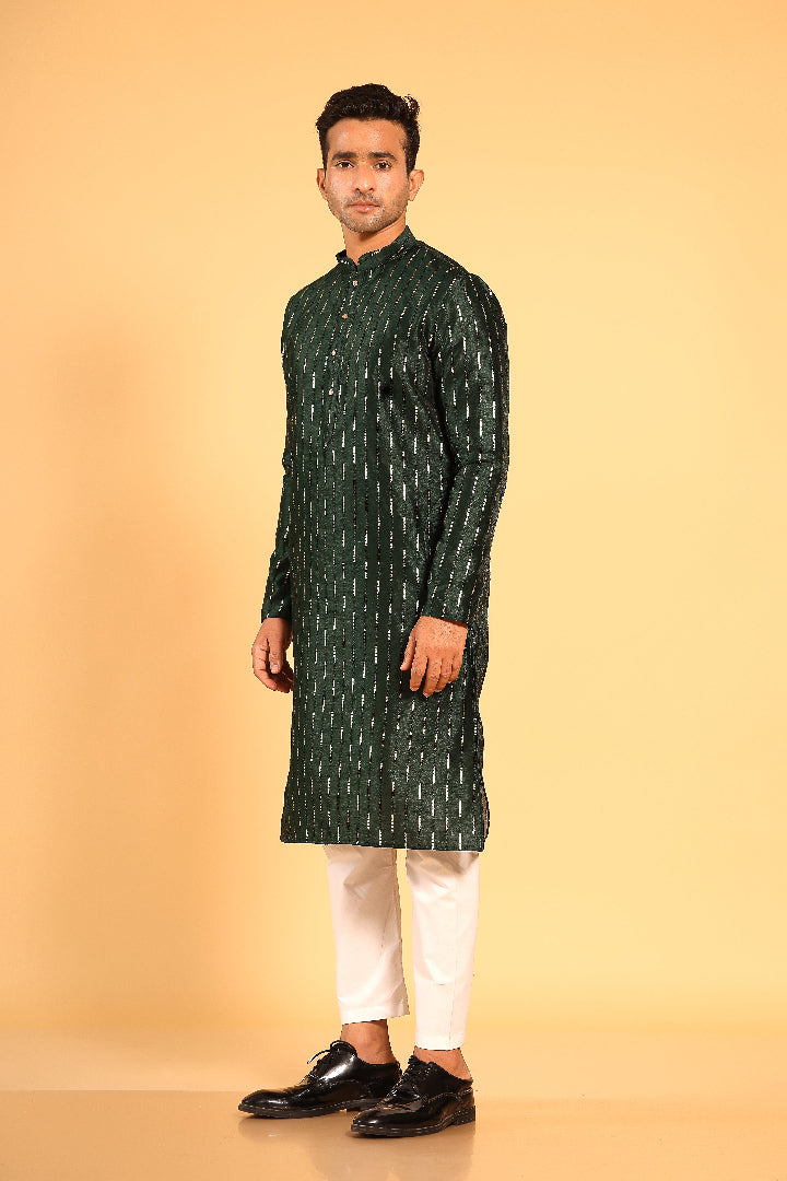 This Mehendi Green silk-blend kurta is designed for comfort and elegance, featuring tone-on-tone threadwork with sequin detailing that runs horizontally for a striking yet subtle effect. Ideal for pujas, haldi, and festive occasions, the kurta is adorned with meenakari buttons along the front placket and finished with a mandarin collar. The knee-length hem adds to its traditional charm, making it a versatile choice for special celebrations.