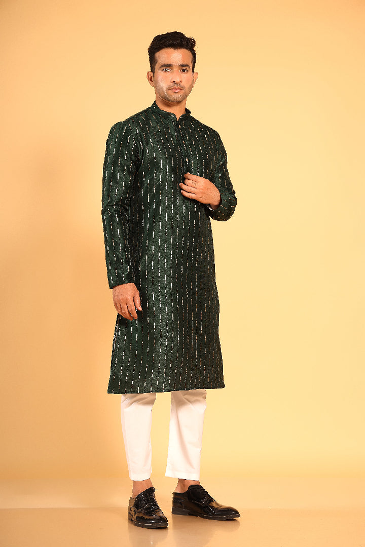 This Mehendi Green silk-blend kurta is designed for comfort and elegance, featuring tone-on-tone threadwork with sequin detailing that runs horizontally for a striking yet subtle effect. Ideal for pujas, haldi, and festive occasions, the kurta is adorned with meenakari buttons along the front placket and finished with a mandarin collar. The knee-length hem adds to its traditional charm, making it a versatile choice for special celebrations.