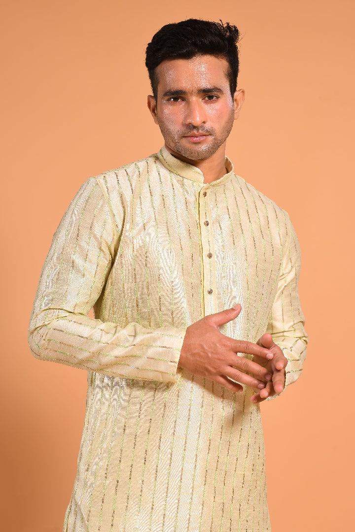This Pista Green silk-blend kurta is designed for comfort and elegance, featuring tone-on-tone threadwork with sequin detailing that runs horizontally for a striking yet subtle effect. Ideal for pujas, haldi, and festive occasions, the kurta is adorned with meenakari buttons along the front placket and finished with a mandarin collar. The knee-length hem adds to its traditional charm, making it a versatile choice for special celebrations.