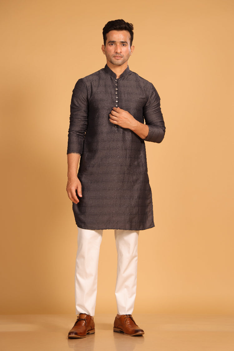 This charcoal gray kurta combines subtle elegance with intricate detailing. Made from a soft, smooth viscose blend, this charcoal gray kurta offers a soft and smooth feel that is gentle on the skin. The intricate all-over threadwork adds texture and detail to the classic design, making it an excellent choice for both formal and festive occasions. The kurta features a mandarin collar and a front placket with meenakari metal buttons, bringing a refined touch to its sleek silhouette.&nbsp;