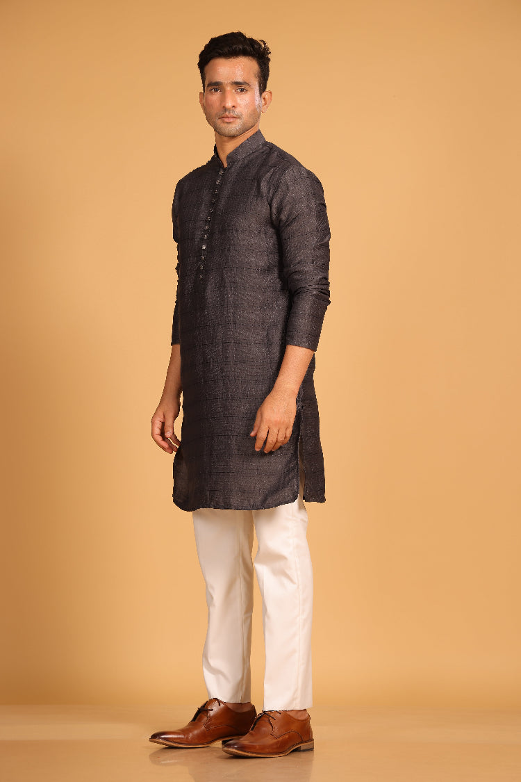 This charcoal gray kurta combines subtle elegance with intricate detailing. Made from a soft, smooth viscose blend, this charcoal gray kurta offers a soft and smooth feel that is gentle on the skin. The intricate all-over threadwork adds texture and detail to the classic design, making it an excellent choice for both formal and festive occasions. The kurta features a mandarin collar and a front placket with meenakari metal buttons, bringing a refined touch to its sleek silhouette.&nbsp;