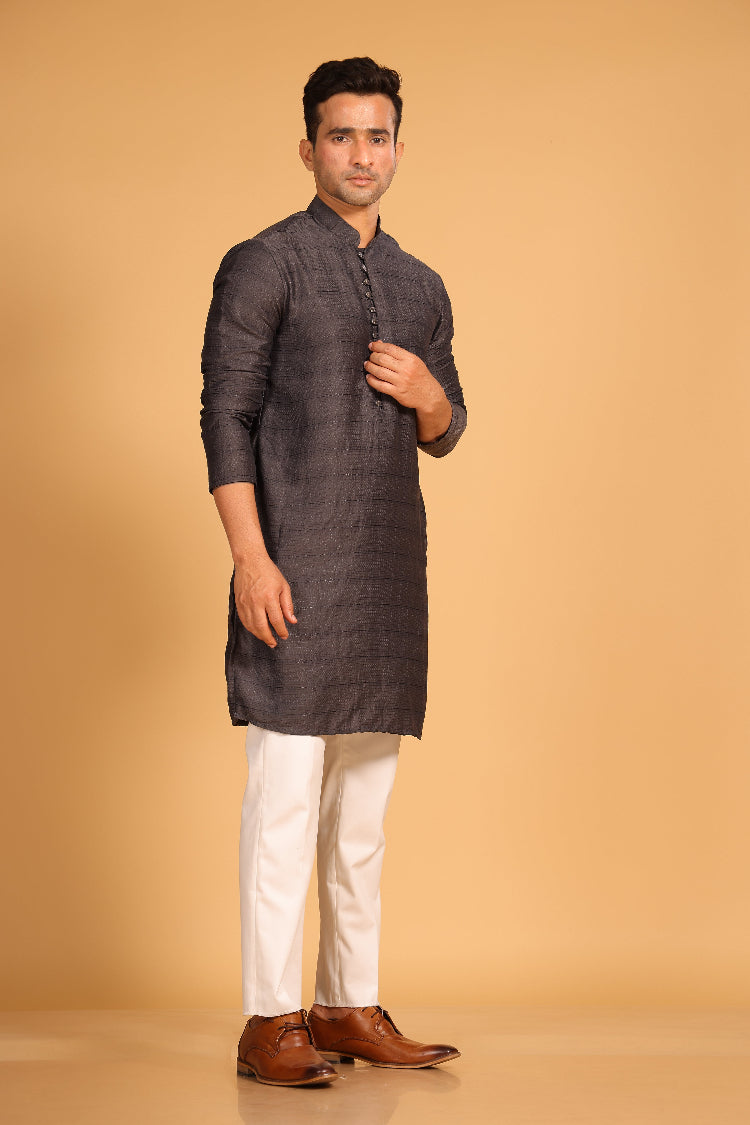 This charcoal gray kurta combines subtle elegance with intricate detailing. Made from a soft, smooth viscose blend, this charcoal gray kurta offers a soft and smooth feel that is gentle on the skin. The intricate all-over threadwork adds texture and detail to the classic design, making it an excellent choice for both formal and festive occasions. The kurta features a mandarin collar and a front placket with meenakari metal buttons, bringing a refined touch to its sleek silhouette.&nbsp;