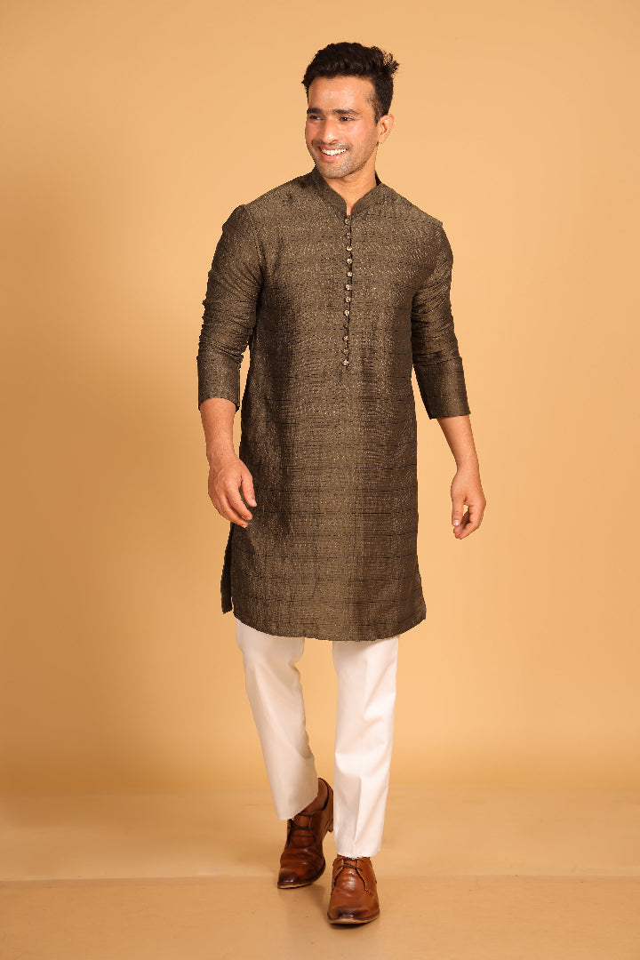 This Mehendi Green kurta combines subtle elegance with intricate detailing. Made from a soft, smooth viscose blend, this charcoal gray kurta offers a soft and smooth feel that is gentle on the skin. The intricate all-over threadwork adds texture and detail to the classic design, making it an excellent choice for both formal and festive occasions. The kurta features a mandarin collar and a front placket with meenakari metal buttons, bringing a refined touch to its sleek silhouette.