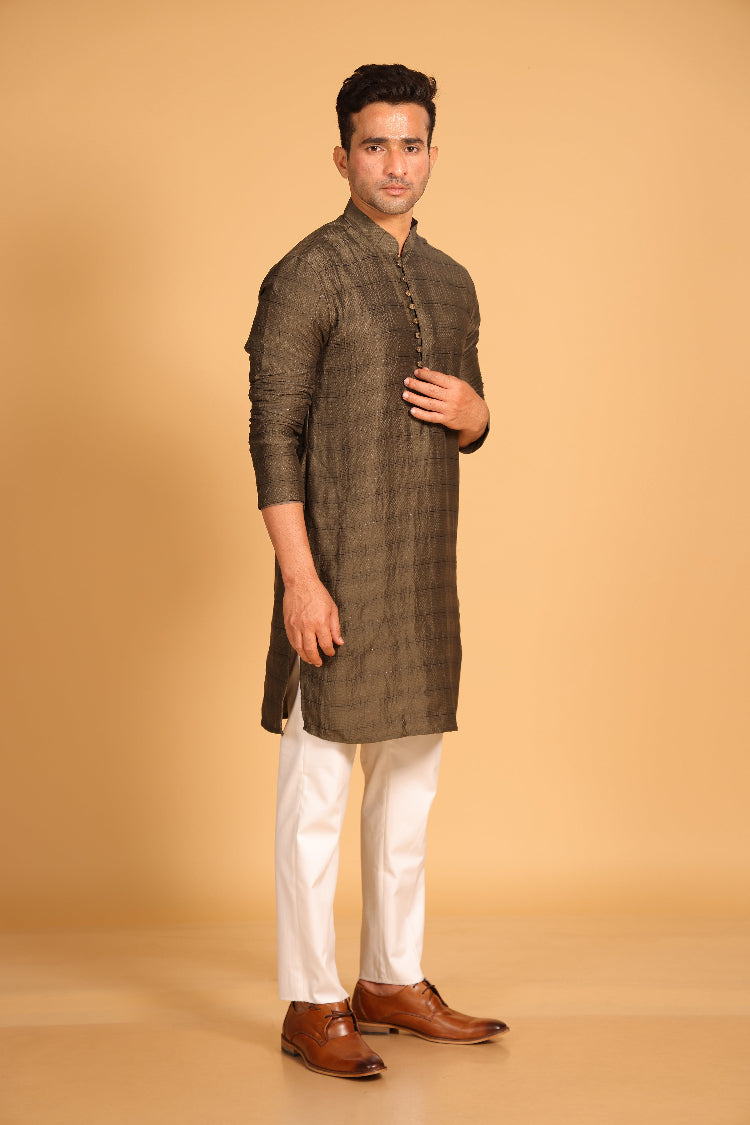 This Mehendi Green kurta combines subtle elegance with intricate detailing. Made from a soft, smooth viscose blend, this charcoal gray kurta offers a soft and smooth feel that is gentle on the skin. The intricate all-over threadwork adds texture and detail to the classic design, making it an excellent choice for both formal and festive occasions. The kurta features a mandarin collar and a front placket with meenakari metal buttons, bringing a refined touch to its sleek silhouette.