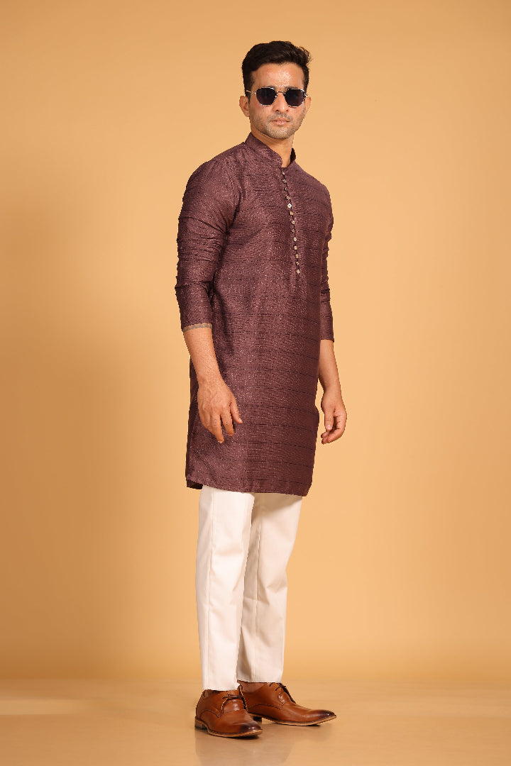 This Mauve kurta combines subtle elegance with intricate detailing. Made from a soft, smooth viscose blend, this charcoal gray kurta offers a soft and smooth feel that is gentle on the skin. The intricate all-over threadwork adds texture and detail to the classic design, making it an excellent choice for both formal and festive occasions. The kurta features a mandarin collar and a front placket with meenakari metal buttons, bringing a refined touch to its sleek silhouette.