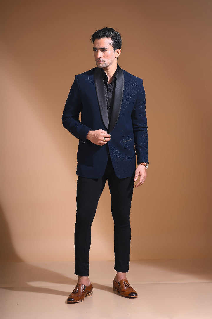 Introducing our stunning Navy Blue Tuxedo Jacket, designed to exude sophistication and class. Made from imported stretchable crepe fabric, this tuxedo jacket offers both a luxurious look and the utmost comfort in movement. The rich Blue color, paired with a standard tuxedo lapel and a sleek single-button front fastening, makes this piece perfect for formal events. The premium jacquard lining inside adds a touch of refinement, while contrasting buttons on the front and sleeves enhance its elegance.