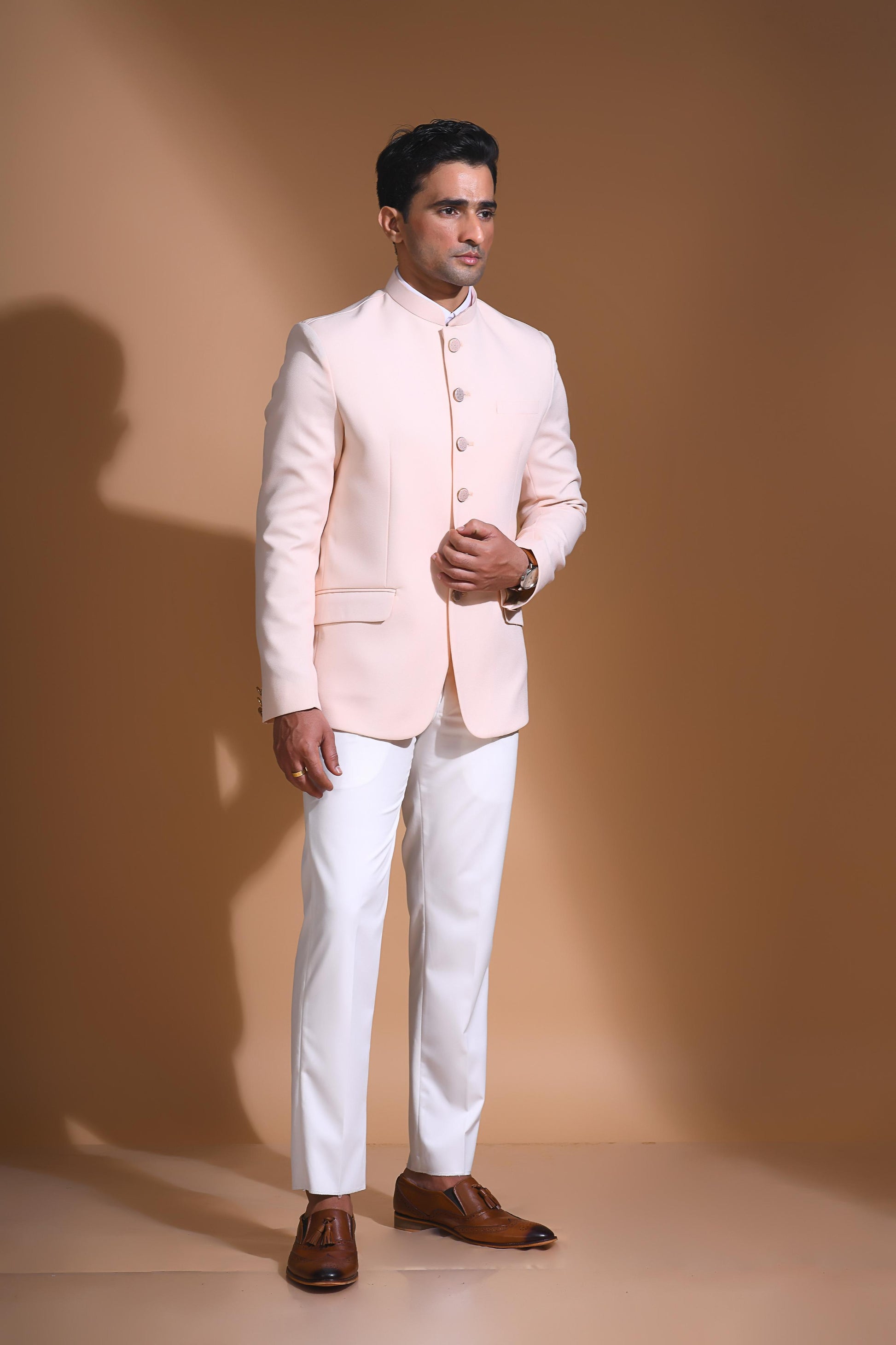 The Light Pink textured bandhgala is designed for those who value timeless elegance and craftsmanship. Made from premium textured suiting fabric, it offers a refined feel and structured drape that enhances your look effortlessly. The bandhgala is accented with 6 contrasting meenakari metal buttons, providing a subtle yet distinct touch of detail. The interior features a premium jacquard lining that ensures both comfort and sophistication.