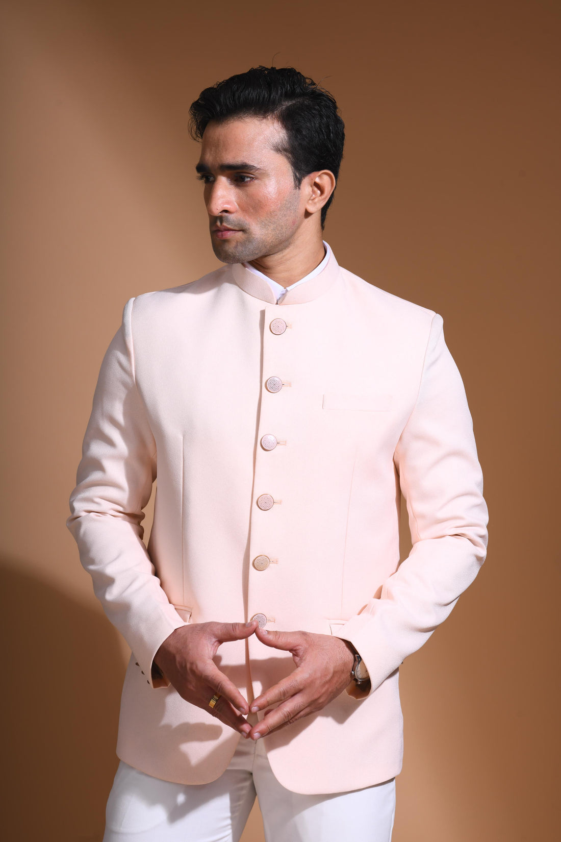 The Light Pink textured bandhgala is designed for those who value timeless elegance and craftsmanship. Made from premium textured suiting fabric, it offers a refined feel and structured drape that enhances your look effortlessly. The bandhgala is accented with 6 contrasting meenakari metal buttons, providing a subtle yet distinct touch of detail. The interior features a premium jacquard lining that ensures both comfort and sophistication.