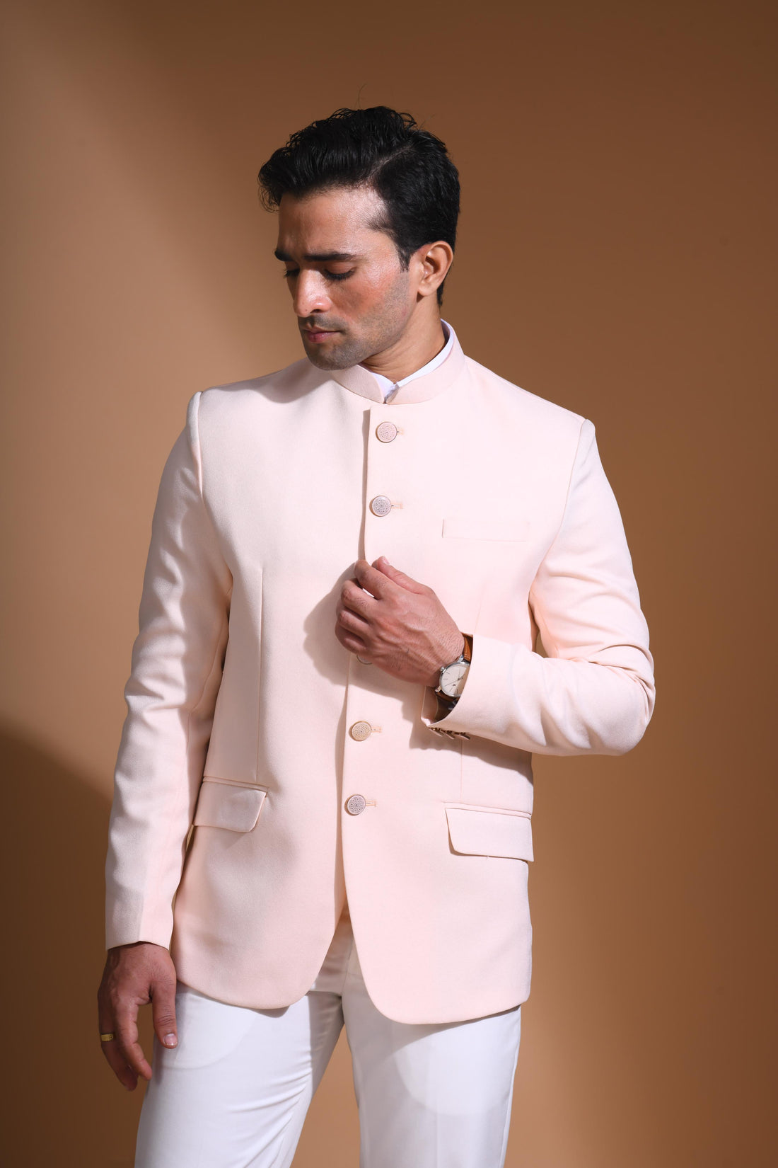 The Light Pink textured bandhgala is designed for those who value timeless elegance and craftsmanship. Made from premium textured suiting fabric, it offers a refined feel and structured drape that enhances your look effortlessly. The bandhgala is accented with 6 contrasting meenakari metal buttons, providing a subtle yet distinct touch of detail. The interior features a premium jacquard lining that ensures both comfort and sophistication.