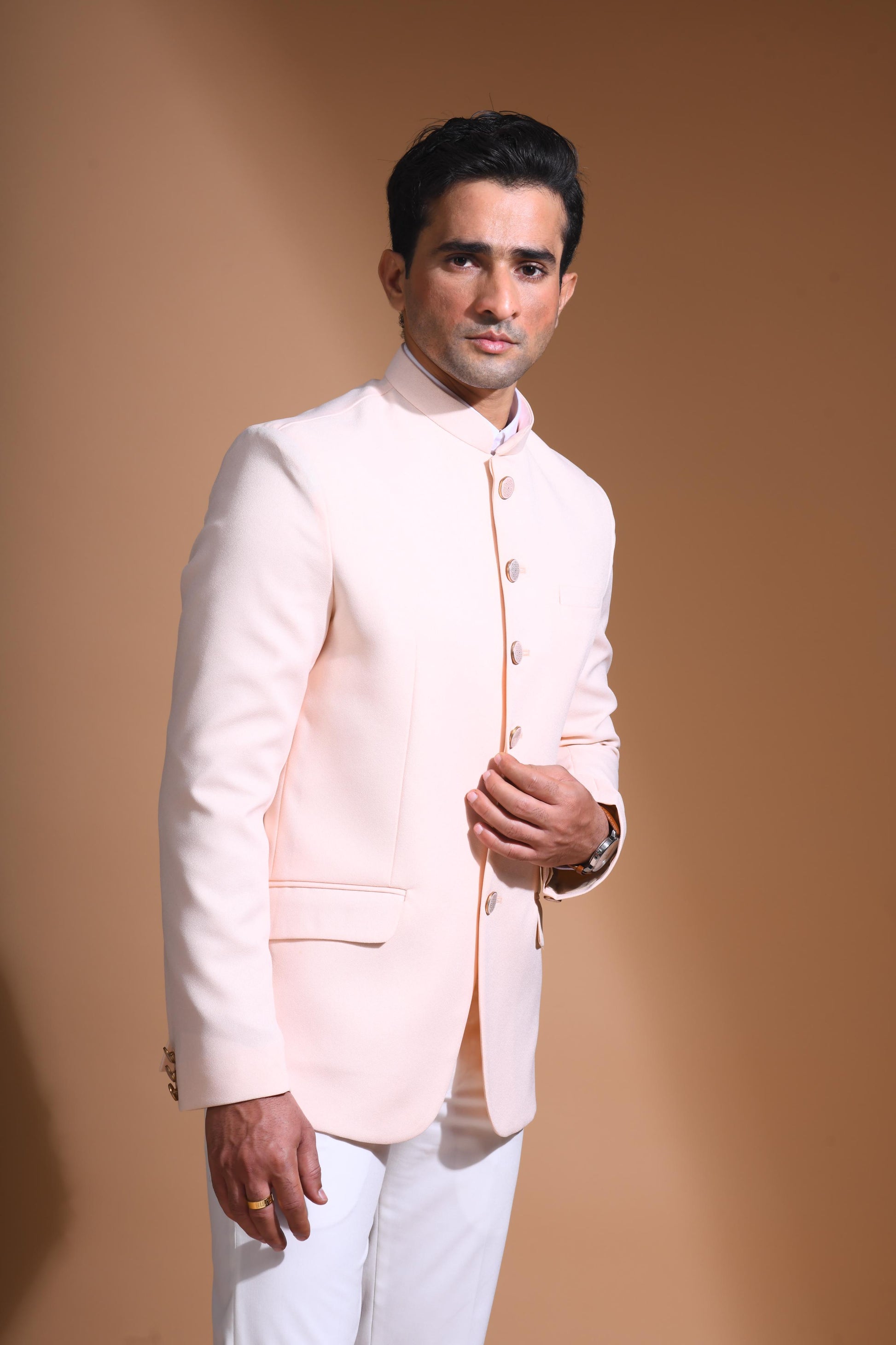 The Light Pink textured bandhgala is designed for those who value timeless elegance and craftsmanship. Made from premium textured suiting fabric, it offers a refined feel and structured drape that enhances your look effortlessly. The bandhgala is accented with 6 contrasting meenakari metal buttons, providing a subtle yet distinct touch of detail. The interior features a premium jacquard lining that ensures both comfort and sophistication.