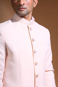 The Light Pink textured bandhgala is designed for those who value timeless elegance and craftsmanship. Made from premium textured suiting fabric, it offers a refined feel and structured drape that enhances your look effortlessly. The bandhgala is accented with 6 contrasting meenakari metal buttons, providing a subtle yet distinct touch of detail. The interior features a premium jacquard lining that ensures both comfort and sophistication.