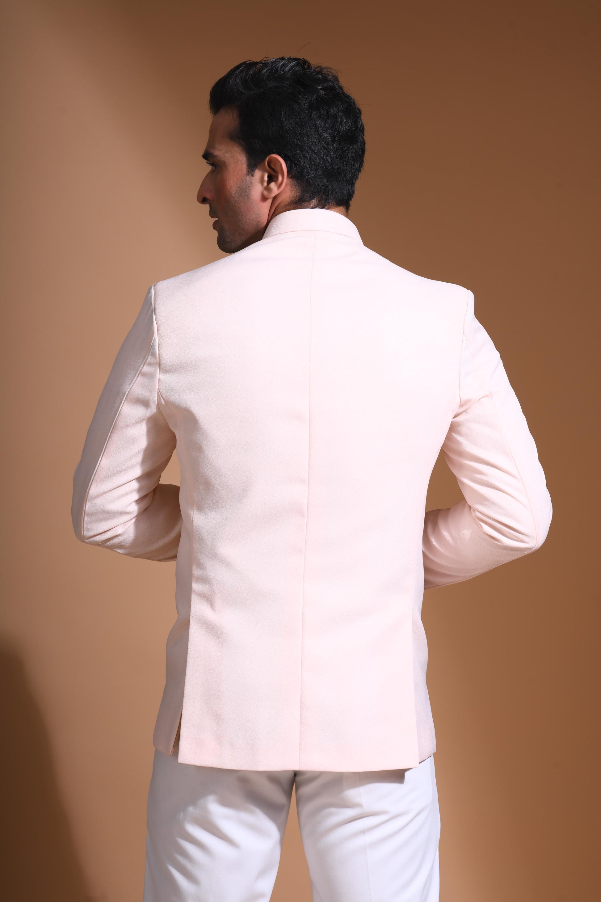 The Light Pink textured bandhgala is designed for those who value timeless elegance and craftsmanship. Made from premium textured suiting fabric, it offers a refined feel and structured drape that enhances your look effortlessly. The bandhgala is accented with 6 contrasting meenakari metal buttons, providing a subtle yet distinct touch of detail. The interior features a premium jacquard lining that ensures both comfort and sophistication.
