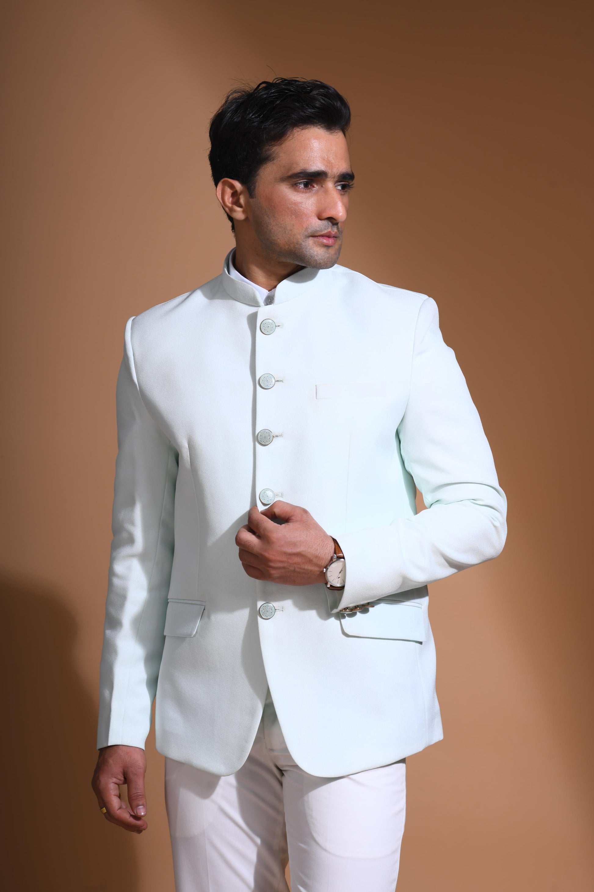 The Cyan Blue textured bandhgala is designed for those who value timeless elegance and craftsmanship. Made from premium textured suiting fabric, it offers a refined feel and structured drape that enhances your look effortlessly. The bandhgala is accented with 6 contrasting meenakari metal buttons, providing a subtle yet distinct touch of detail. The interior features a premium jacquard lining that ensures both comfort and sophistication.