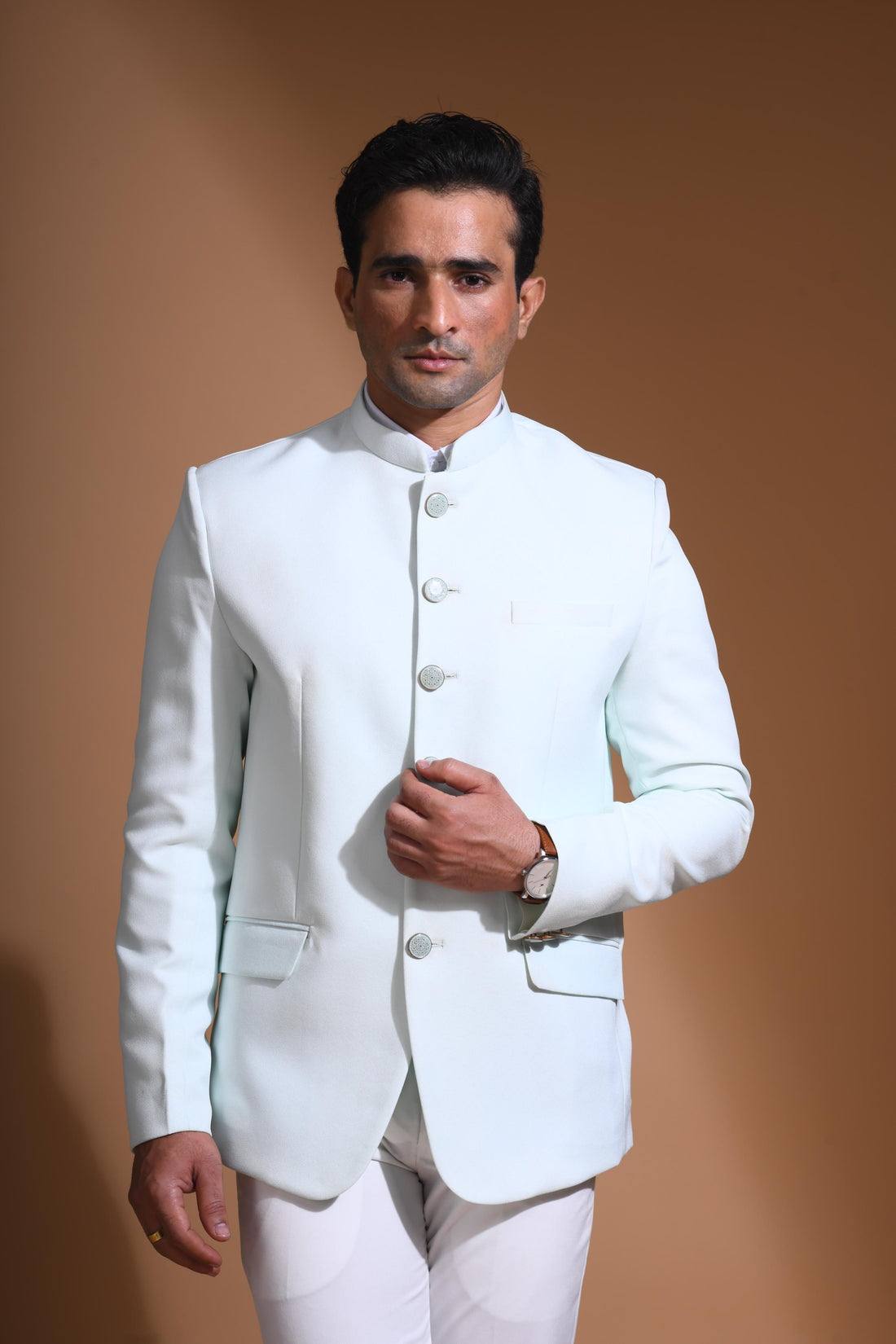 The Cyan Blue textured bandhgala is designed for those who value timeless elegance and craftsmanship. Made from premium textured suiting fabric, it offers a refined feel and structured drape that enhances your look effortlessly. The bandhgala is accented with 6 contrasting meenakari metal buttons, providing a subtle yet distinct touch of detail. The interior features a premium jacquard lining that ensures both comfort and sophistication.