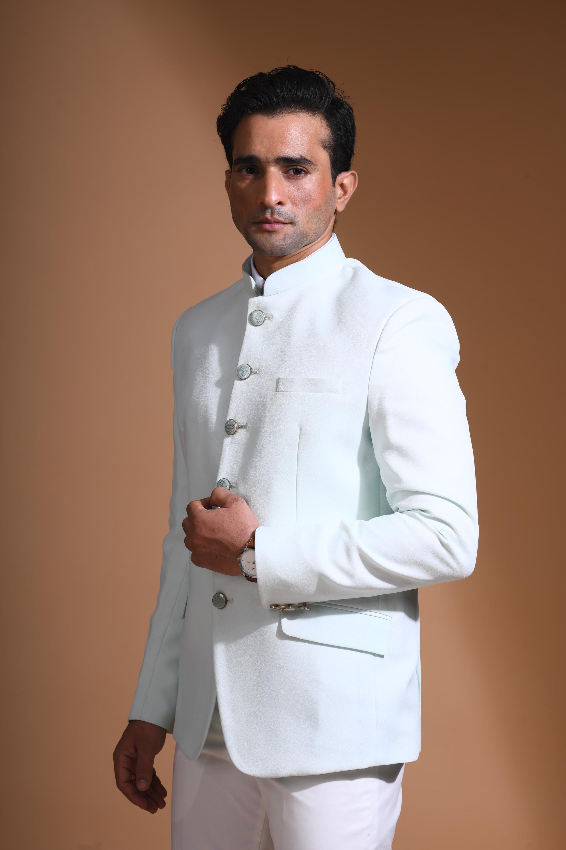 The Cyan Blue textured bandhgala is designed for those who value timeless elegance and craftsmanship. Made from premium textured suiting fabric, it offers a refined feel and structured drape that enhances your look effortlessly. The bandhgala is accented with 6 contrasting meenakari metal buttons, providing a subtle yet distinct touch of detail. The interior features a premium jacquard lining that ensures both comfort and sophistication.