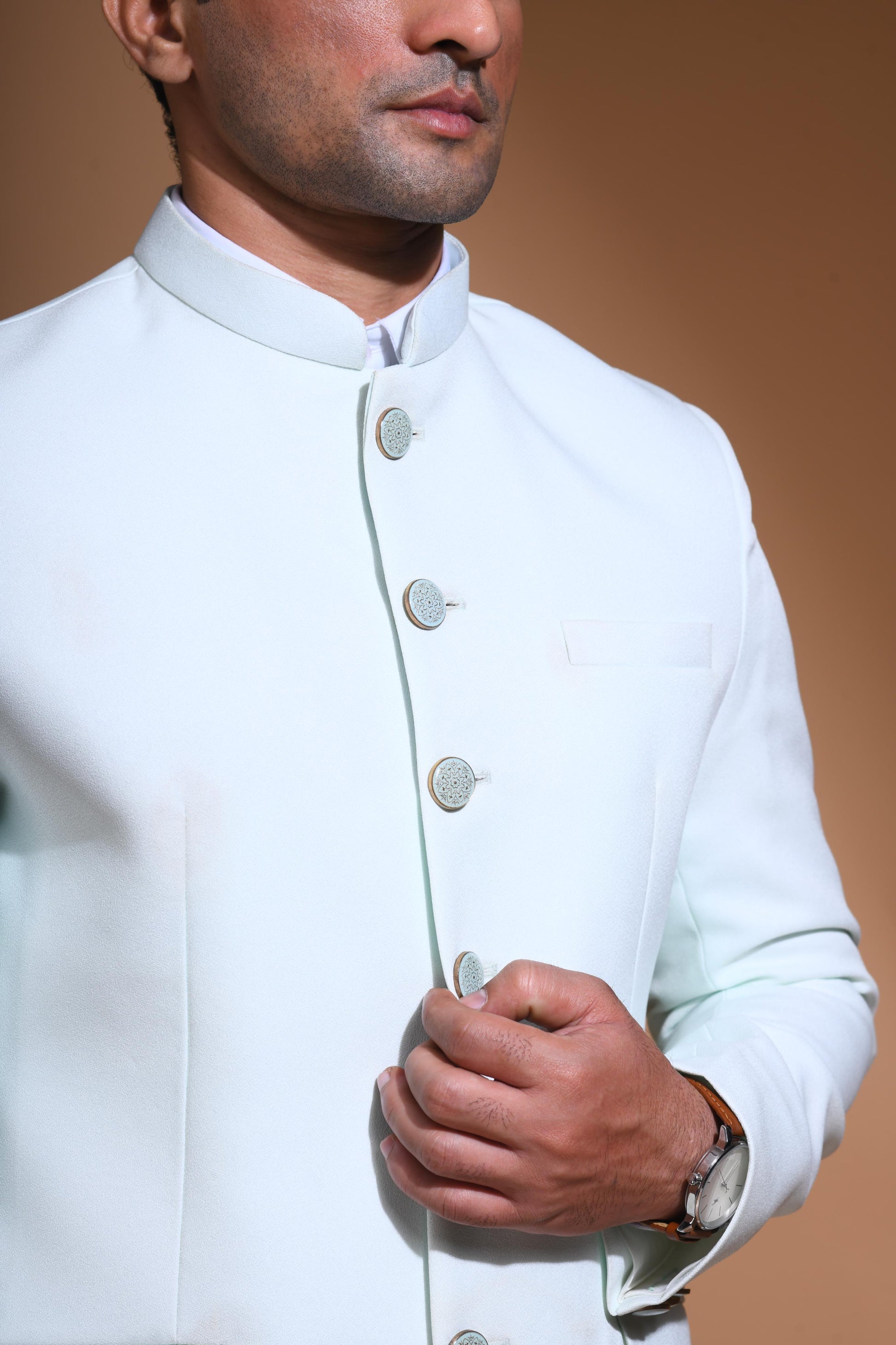 The Cyan Blue textured bandhgala is designed for those who value timeless elegance and craftsmanship. Made from premium textured suiting fabric, it offers a refined feel and structured drape that enhances your look effortlessly. The bandhgala is accented with 6 contrasting meenakari metal buttons, providing a subtle yet distinct touch of detail. The interior features a premium jacquard lining that ensures both comfort and sophistication.