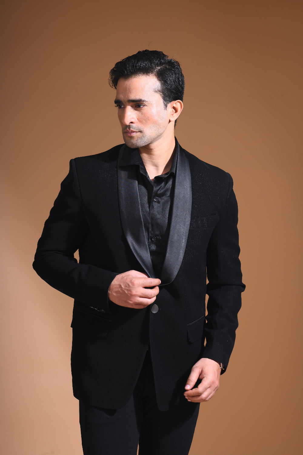 Introducing our stunning Black Tuxedo Jacket, designed to exude sophistication and class. Made from imported stretchable crepe fabric, this tuxedo jacket offers both a luxurious look and the utmost comfort in movement. The rich Black color, paired with a standard tuxedo lapel and a sleek single-button front fastening, makes this piece perfect for formal events. The premium jacquard lining inside adds a touch of refinement, while contrasting buttons on the front and sleeves enhance its  elegance. 