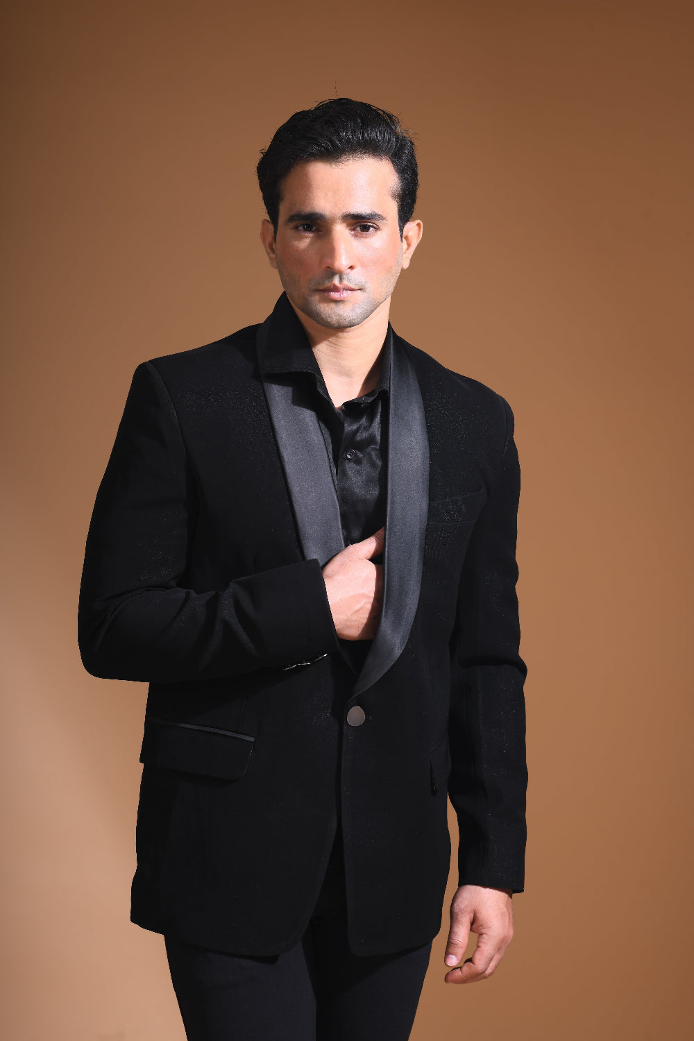 Introducing our stunning Black Tuxedo Jacket, designed to exude sophistication and class. Made from imported stretchable crepe fabric, this tuxedo jacket offers both a luxurious look and the utmost comfort in movement. The rich Black color, paired with a standard tuxedo lapel and a sleek single-button front fastening, makes this piece perfect for formal events. The premium jacquard lining inside adds a touch of refinement, while contrasting buttons on the front and sleeves enhance its  elegance. 