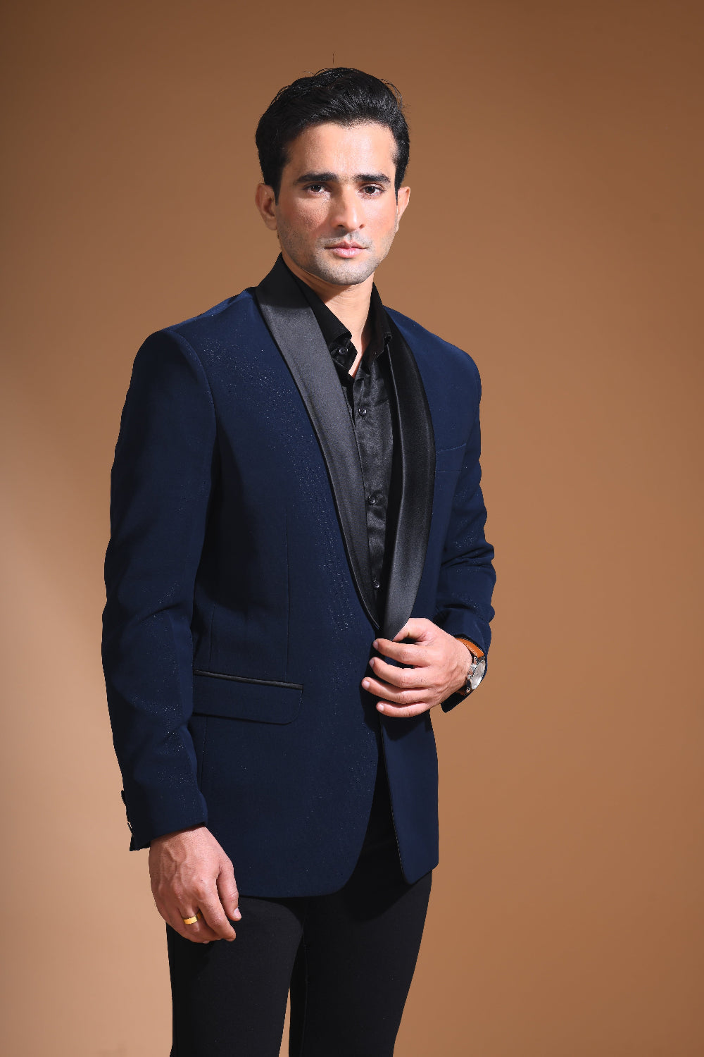 Introducing our stunning Navy Blue Tuxedo Jacket, designed to exude sophistication and class. Made from imported stretchable crepe fabric, this tuxedo jacket offers both a luxurious look and the utmost comfort in movement. The rich Blue color, paired with a standard tuxedo lapel and a sleek single-button front fastening, makes this piece perfect for formal events. The premium jacquard lining inside adds a touch of refinement, while contrasting buttons on the front and sleeves enhance its elegance.